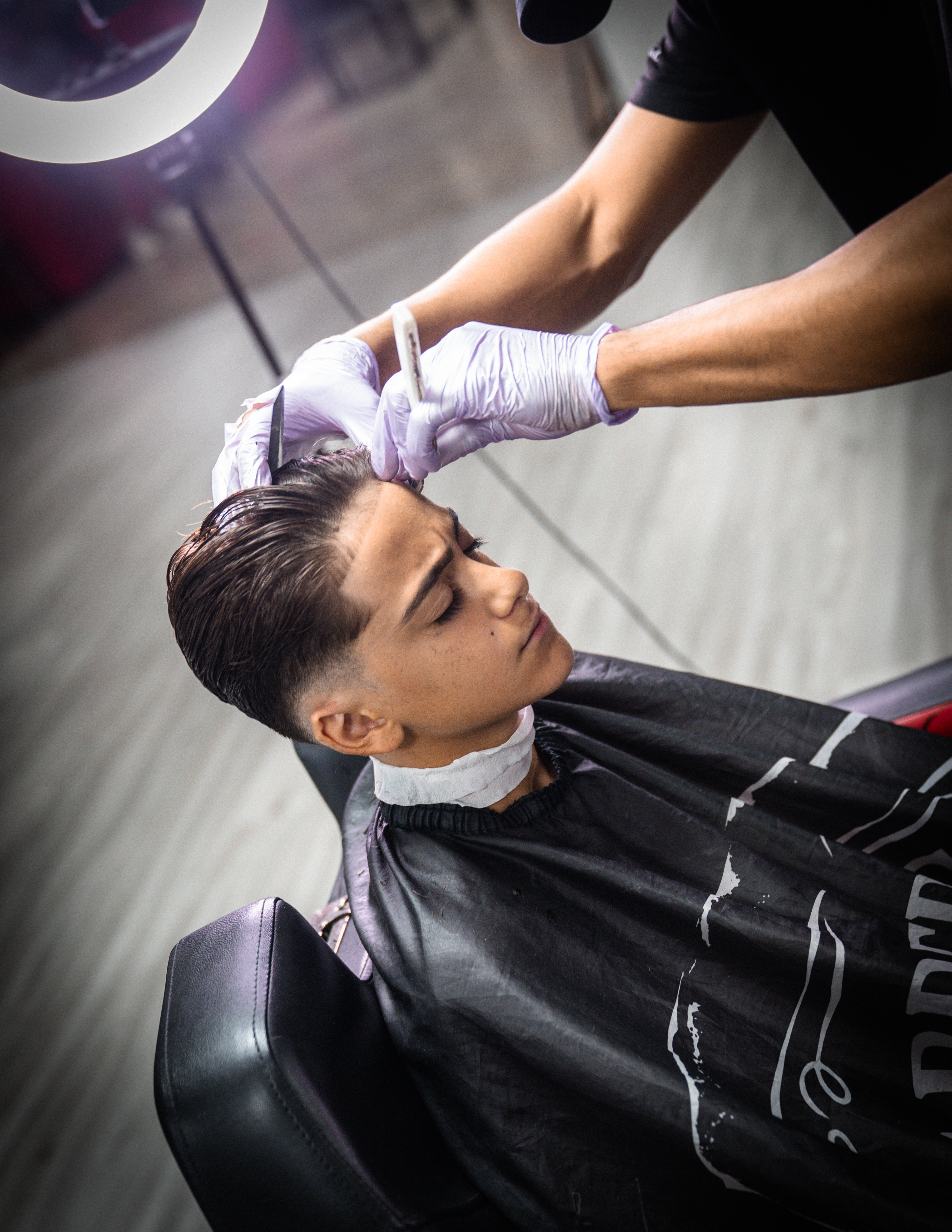 A barber giving a shave with a straight razor